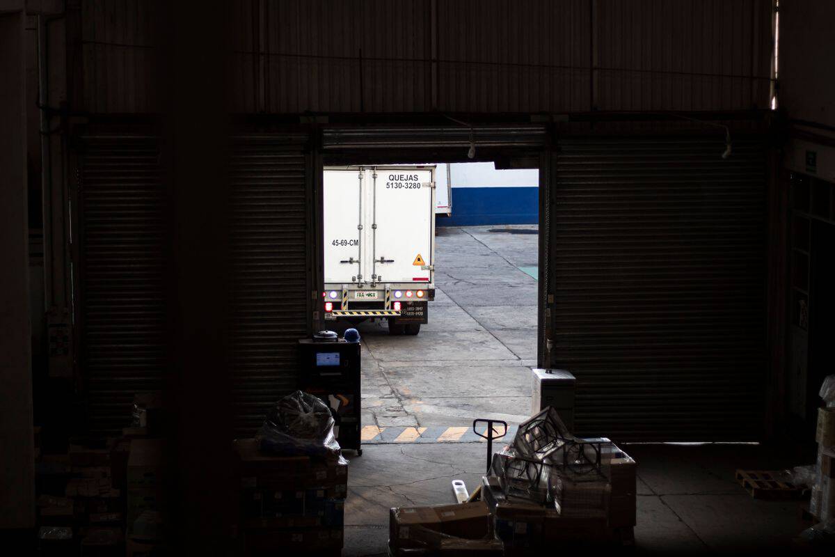 Cost of a vacant warehouse leadership role shown at a busy loading dock under pressure